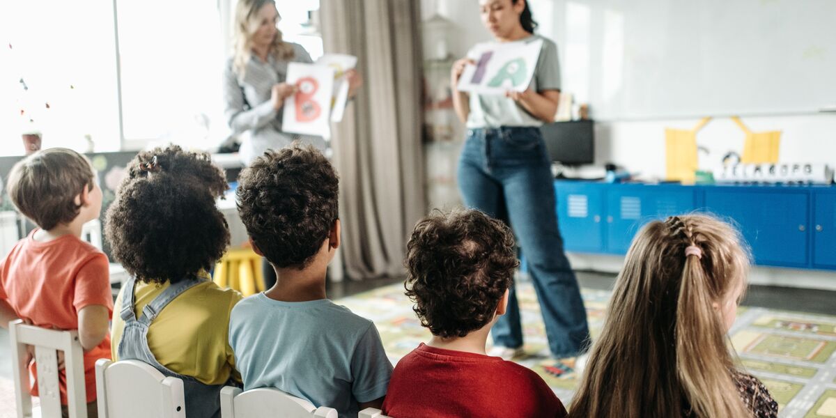 Aula con niños trabajando en sus cuadernos junto a su docente